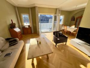 a living room with a couch and a table at Hotel Waldhaus am See in St. Moritz