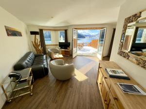 a living room with a leather couch and a table at Hotel Waldhaus am See in St. Moritz
