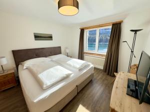 a bedroom with a large white bed and a window at Hotel Waldhaus am See in St. Moritz +110 photos