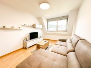 a living room with a couch and a television at Apartamento Luzada by ALÔGA in Cee