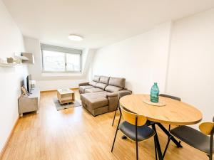 a living room with a table and a couch at Apartamento Luzada by ALÔGA in Cee
