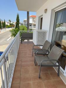 a balcony with chairs and a view of a street at T1 Apartment Cabanas in Cabanas de Tavira