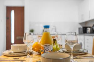 a table with two glasses and a bottle of orange juice at Parking Outside Terrace Balcony Fulham ST in London