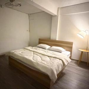 een slaapkamer met een bed met witte lakens en kussens bij Box me in Bangkok