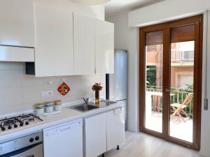a white kitchen with a sink and a stove at Birsa's Rooms in Cagliari
