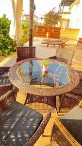 eine Terrasse mit einem Tisch und Korbstühlen sowie einem Glastisch und Stühlen in der Unterkunft Frontline Paradise on the Water's edge in Tatlisu, North Cyprus in Famagusta