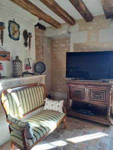 a living room with a couch and a television at Chambres d'Hôtes L'Ecu in Preuilly-sur-Claise