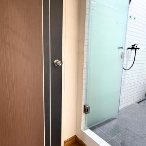 een douche met een glazen deur en een douche bij Box me in Bangkok