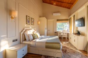 Un dormitorio con una cama grande y una mesa. en Casa De Bello, Nainital, Near Kainchi Dham, en Bhowāli