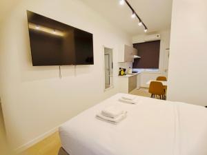a white room with a flat screen tv on a wall at Central Retreat by Zeus Suites in Athens