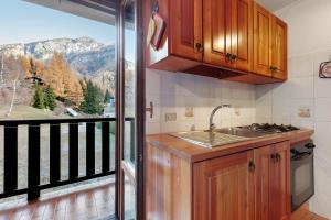 une cuisine avec un évier et un balcon avec vue dans l'établissement Da Gigi e Laura, à Cogne