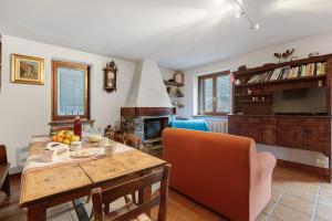 un salon avec une table et une cheminée dans l'établissement Da Gigi e Laura, à Cogne