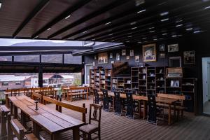 a library with wooden tables and chairs and shelves of books at HOME 12 in Librazhd