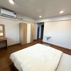 een slaapkamer met een wit bed en een wastafel bij Box me in Bangkok +3 foto's