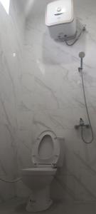 ein weißes Bad mit einem WC und einem Seifenspender in der Unterkunft Villa Kopi Klotok in Pasuruan