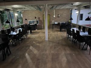 a man standing in a dining room with tables and chairs at Kohuwa Resort in Jyoti Gaon +7 photos