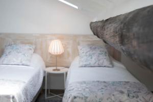 una camera da letto con due letti e una lampada su un tavolo di Islet House a São Roque