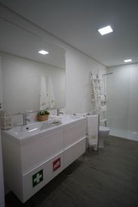 a bathroom with a sink and a toilet and a mirror at Islet House in São Roque +23 photos