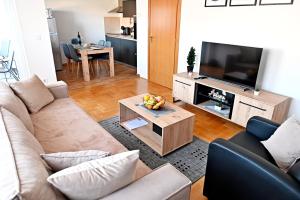 a living room with a couch and a television at Apartman Maela in Županja