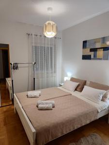 une chambre avec un grand lit avec deux serviettes dessus dans l'établissement Apartman Maela, à Županja