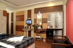 una habitación de hotel con una cama y un televisor en Sonar Bangla's Motel Midway, en Howrah