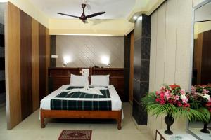 ein Schlafzimmer mit einem Bett und Blumen in einem Zimmer in der Unterkunft Sonar Bangla's Motel Midway in Howrah