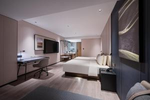 une chambre d'hôtel avec un lit et un bureau dans l'établissement Atour Hotel Wuhan Riverview Jianghan Road Pedestrian Street, à Wuhan