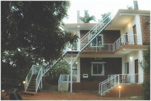 a house with a staircase in front of it at Lagoon Stays, Gokarna in Gokarna