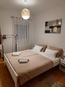a bedroom with a large bed with two towels on it at Apartman Maela in Županja