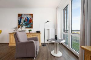 a living room with a chair and a window at Dorfring 36 Seeadler in Stein