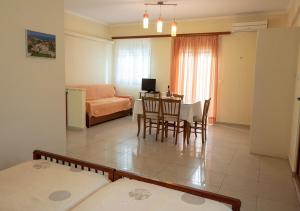 a living room with a table and a dining room at Erietta Studios & Apartments by Kika Residences in Stoupa
