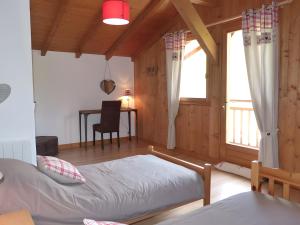 Un dormitorio con una cama y un escritorio y una ventana. en Chalet La Transhumance, en Combloux