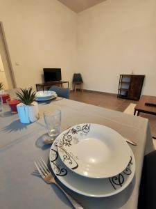 une plaque blanche sur une table avec une fourchette et un couteau dans l'établissement Le tarasconnais, séjour authentique en Provence, à Tarascon