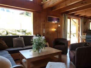 Una sala de estar con sofás y una mesa de café. en Chalet La Transhumance, en Combloux