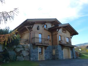 una gran casa de madera con un muro de piedra en Chalet La Transhumance, en Combloux