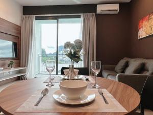 un salon avec une table avec un vase de fleurs dans l'établissement Sunway Onsen Suite Cozy Homestay, à Ipoh