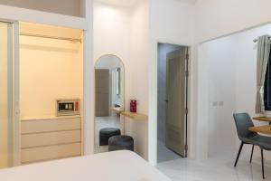 a bedroom with a bed and a mirror at Garto Beach Resort Samui in Ban Thong Phlu