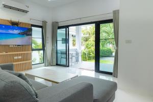 a living room with a couch and a table at Garto Beach Resort Samui in Ban Thong Phlu
