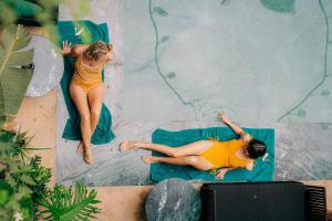 Dos chicas en traje de baño están en una piscina. en Riad Nashira & Spa, en Marrakech
