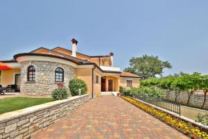 a house with a brick driveway in front of it at Schöne Ferienvilla Morena Mit Pool in Kaštel