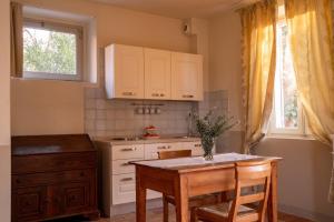 une cuisine avec des armoires blanches et une table avec des chaises dans l'établissement Marica, à Pesaro