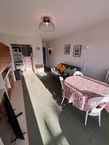 ein Wohnzimmer mit einem Tisch und einem Sofa in der Unterkunft Ti Hou - T2 600 m plage - Lajarrige in La Baule-les-Pins