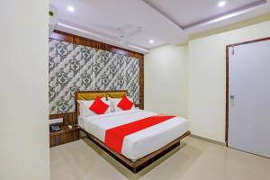 a bedroom with a large bed with red pillows at Hotel O Golden in Vadodara