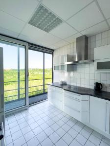 a kitchen with white appliances and a large window at Unterkünfte Buchholz in Buchholz in der Nordheide