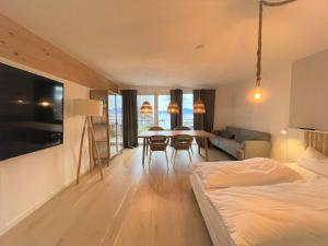 a room with a bed and a table and chairs at QC Quartier Chiemsee Hotel in Seebruck