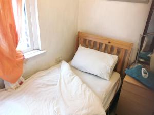 a bed with a white pillow and a window at 1st floor Large single room for one person in Rotherham plus kitchen in Rawmarsh