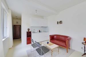 a living room with a red couch and a table at Cozy Studio 2P – Montmartre in Paris