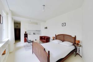 a bedroom with a bed and a kitchen at Cozy Studio 2P – Montmartre in Paris +4 photos