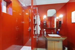 a bathroom with red walls and a shower and a sink at Cozy Studio 2P – Montmartre in Paris