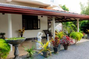 a patio with a fountain and plants in front of a house at Mahagedara Hiriketiya in Dickwella